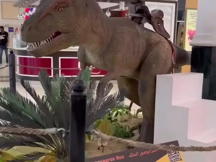 A T-Rex beside an information panel along the mall corridor