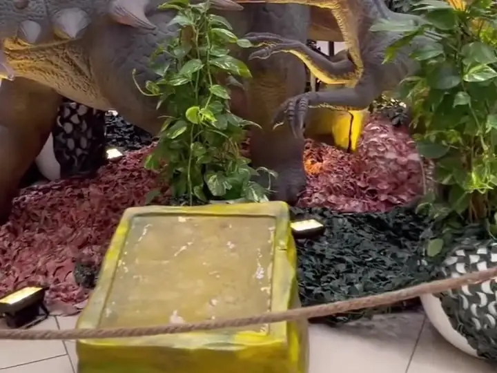 An armoured dinosaur among plants in front of the shops