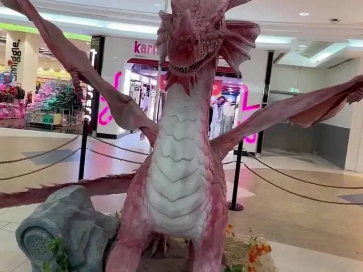 A red dragon with open wings beside the shops at City Center Doha